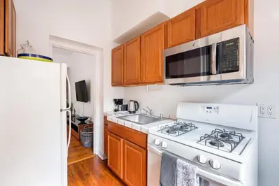 a kitchen with a white stove and a microwave at Bright and Comfy Studio in NYC in New York