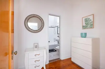 a bathroom with a mirror and a white dresser at Bright and Comfy Studio in NYC in New York