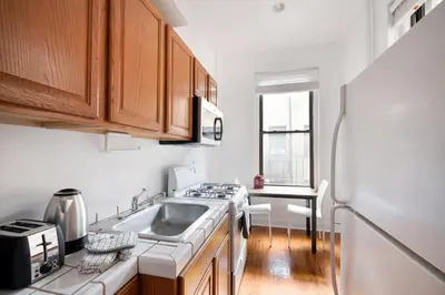 a kitchen with a sink and a refrigerator at Bright and Comfy Studio in NYC in New York