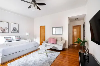 a white living room with a bed and a couch at Bright and Comfy Studio in NYC in New York