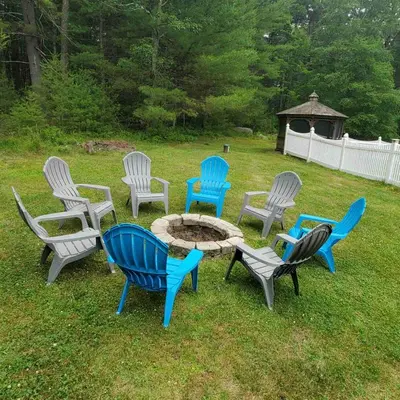a group of chairs and a table in the grass at Spacious House with a Pool in Glen Spey