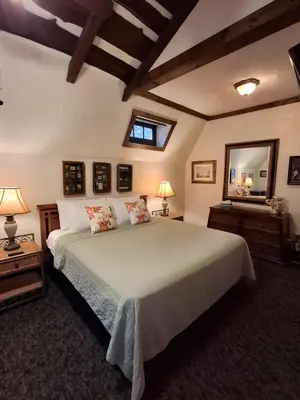 a bedroom with a large bed and a mirror at Inn at Lake Joseph in Forestburgh