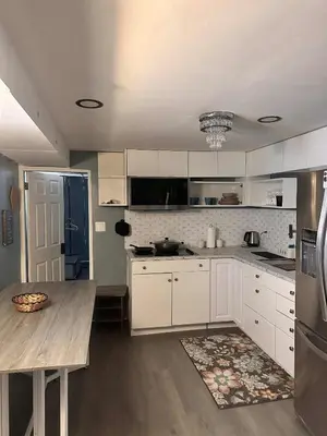 a kitchen with white cabinets and a table in it at Suhira Hospitality in Lansdowne