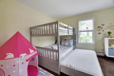a bedroom with two bunk beds and a pink umbrella at Remodeled 4BR w Yard, Fire Pit, Near Camelback in Tannersville