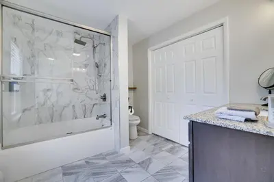 a bathroom with a shower with a glass door at Remodeled 4BR w Yard, Fire Pit, Near Camelback in Tannersville