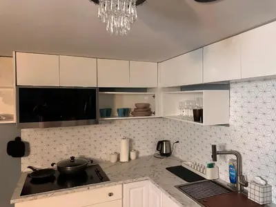 a kitchen with white cabinets and a sink at Suhira Hospitality Group in Lansdowne