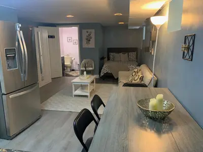 a kitchen and living room with a table and refrigerator at Suhira Hospitality Group in Lansdowne