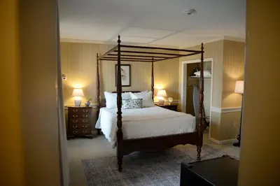 a bedroom with a canopy bed and two lamps at Strasburg Village Inn in Strasburg
