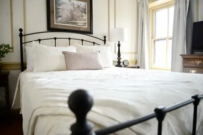 a bedroom with a large bed with white sheets and pillows at Strasburg Village Inn in Strasburg