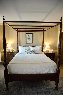 a bedroom with a large bed with two lamps on tables at Strasburg Village Inn in Strasburg