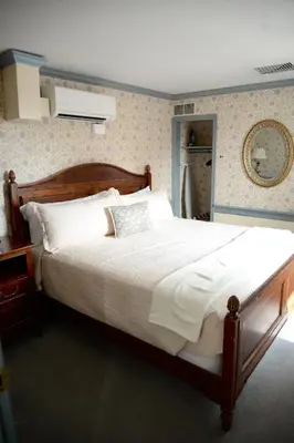 a bedroom with a large bed with white sheets at Strasburg Village Inn in Strasburg