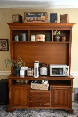 a wooden shelf with a microwave on top of it at Strasburg Village Inn in Strasburg