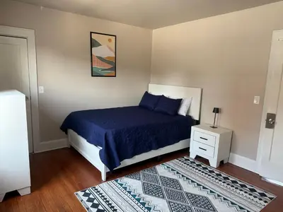 a bedroom with a bed with a blue bedspread and a night stand at Judees' Comfort 3 in Newark