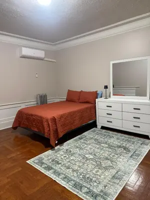 a bedroom with a bed and a dresser and a mirror at Judees' Comfort 3 in Newark