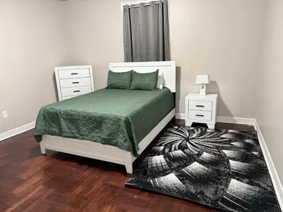 a bedroom with a bed with a green comforter at Judees' Comfort 3 in Newark