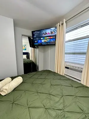 a bedroom with a large bed and a flat screen tv at BP STAYS - Hotel-Style, No Host, Professionally Managed ID252 in Jersey City