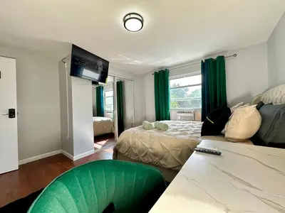 a living room with a couch and a bed and a tv at BP STAYS - Hotel-Style, No Host, Professionally Managed ID252 in Jersey City