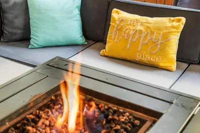 a pillow sitting on a couch next to a fire at Hideaway Hot Tub Sunna Lake Kayaks Pool in Bushkill
