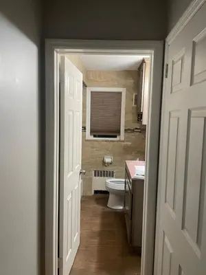 a bathroom with a toilet and a sink and a door at The Vault in Hillside