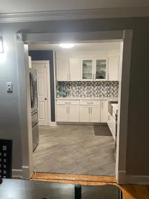 a kitchen with white cabinets and a refrigerator at The Vault in Hillside