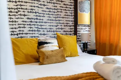 a bedroom with a bed with yellow pillows at Bright & Bold+NYC View, Sleep 13, Park 2 cars FREE in East Orange