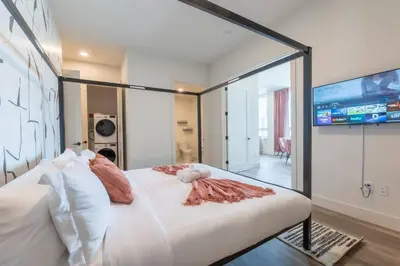 a bedroom with a large white bed and a tv at Bright & Bold+NYC View, Sleep 13, Park 2 cars FREE in East Orange
