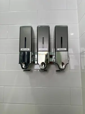 a row of three soap dispensers on a wall at BP STAYS - Hotel-Style, No Host, Professionally Managed ID255 in Jersey City