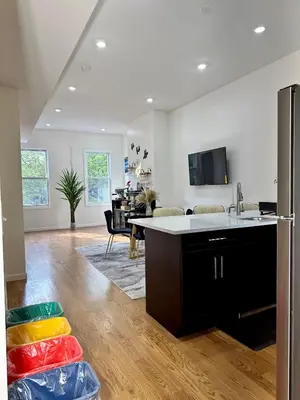 a kitchen with a refrigerator and a living room at BP STAYS - Hotel-Style, No Host, Professionally Managed ID255 in Jersey City