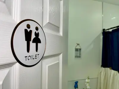 a bathroom door with a toilet sign on it at BP STAYS - Hotel-Style, No Host, Professionally Managed ID255 in Jersey City