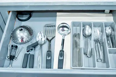 a drawer filled with silver utensils in a container at The Cozy Grey Haven Home - 1st floor in Reading