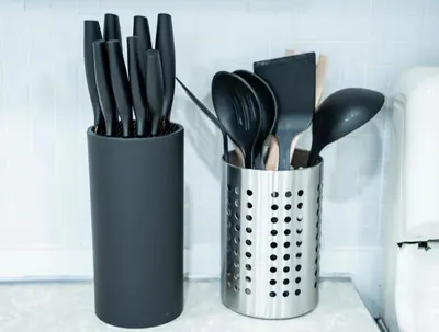 a container filled with utensils on a counter at The Cozy Grey Haven Home - 1st floor in Reading