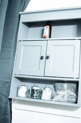 a white cabinet with jars and a bottle on it at The Cozy Grey Haven Home - 1st floor in Reading