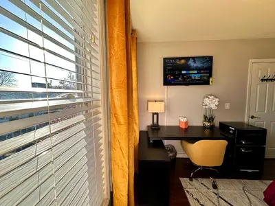a room with a desk and a window with a television at Hotel-Style, No Host, Professionally Managed ID267 in Jersey City
