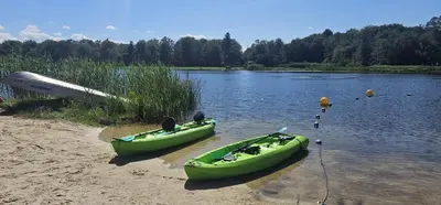 two green canoes on the shore of a lake at Cozy Retreat in Scenic Poconos in Tobyhanna