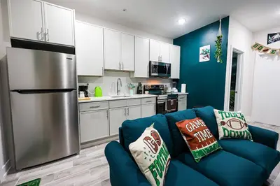a living room with a blue couch in a kitchen at Perch in Paradise EaglesThemed Escape in Philadelphia
