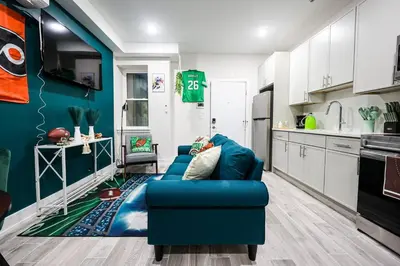 a living room with a blue couch in a kitchen at Perch in Paradise EaglesThemed Escape in Philadelphia