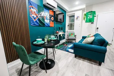 a living room with a blue couch and a table at Perch in Paradise EaglesThemed Escape in Philadelphia