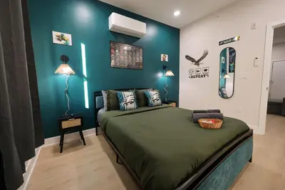 a bedroom with a bed and a blue wall at Fly Eagles Fly StayPhilly Adventure in Philadelphia