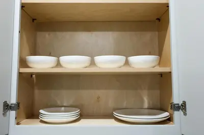 a shelf with bowls and plates in a cabinet at Fly Eagles Fly StayPhilly Adventure in Philadelphia