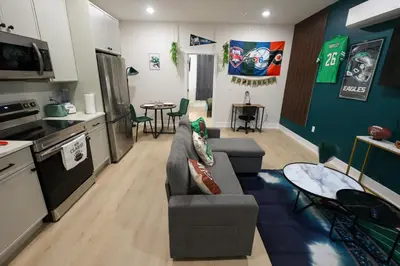 a kitchen and living room with a couch and a table at Fly Eagles Fly StayPhilly Adventure in Philadelphia