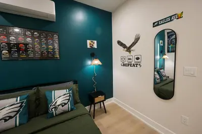 a living room with a couch and a mirror at Fly Eagles Fly StayPhilly Adventure in Philadelphia