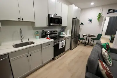 a kitchen with white cabinets and a couch in a room at Fly Eagles Fly StayPhilly Adventure in Philadelphia