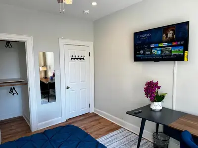 a living room with a table and a tv on the wall at BP STAYS - Hotel-Style, No Host, Professionally Managed ID297 in Jersey City