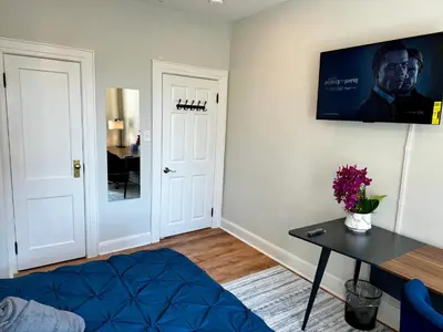 a living room with a table and a tv on the wall at BP STAYS - Hotel-Style, No Host, Professionally Managed ID297 in Jersey City