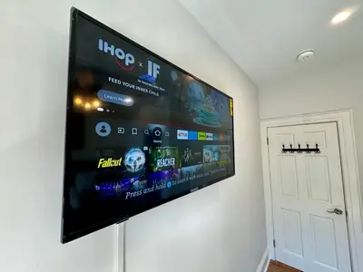 a flat screen tv hanging on a wall at BP STAYS - Hotel-Style, No Host, Professionally Managed ID297 in Jersey City