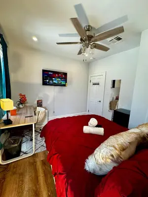 a bedroom with a red bed and a ceiling fan at BP STAYS - Hotel-Style, No Host, Professionally Managed ID297 in Jersey City