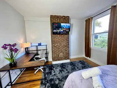 a bedroom with a desk and a brick wall at BP STAYS - Hotel-Style, No Host, Professionally Managed ID265 in Jersey City