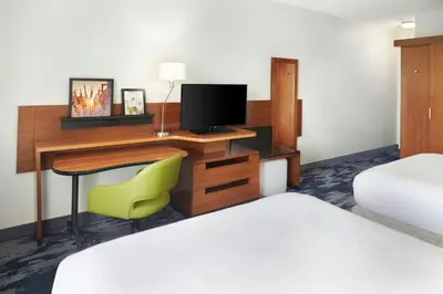 a hotel room with a desk with a television and a bed at Fairfield Inn & Suites by Marriott Reading Wyomissing in Wyomissing