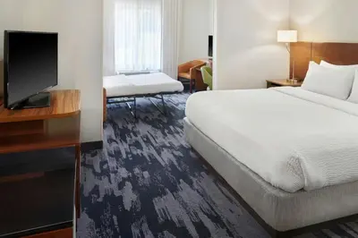 a hotel room with a bed and a flat screen tv at Fairfield Inn & Suites by Marriott Reading Wyomissing in Wyomissing