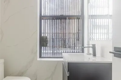 a white bathroom with a sink and a window at Blueground Chinatown washer nr City Hall NYC-1871 in New York